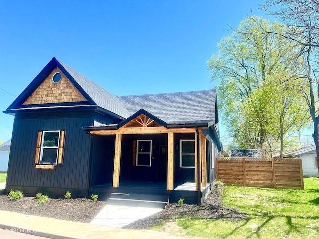 511 N Clark St, Lebanon, IN 46052 - view of front of home with board and batten siding, fence, covered porch, and a shingled roof