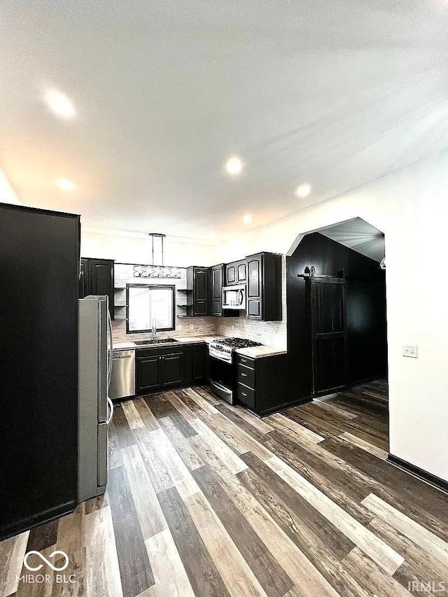 511 N Clark St, Lebanon, IN 46052 - kitchen featuring dark cabinets, light countertops, wood finished floors, stainless steel appliances, and a sink