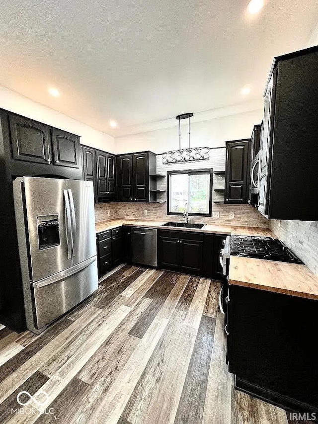 511 N Clark St, Lebanon, IN 46052 - kitchen with light wood-type flooring, tasteful backsplash, appliances with stainless steel finishes, and dark cabinetry