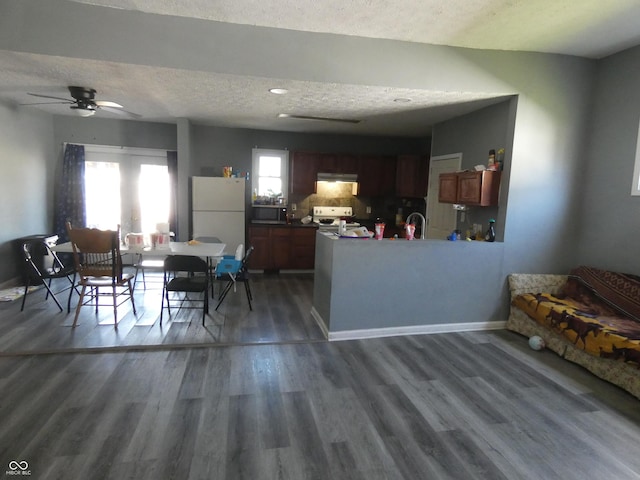 interior space featuring ceiling fan, dark wood-type flooring, baseboards, and a textured ceiling