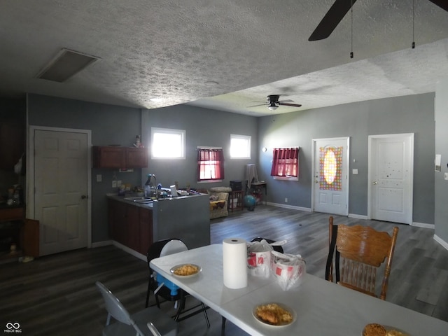 dining space featuring dark wood finished floors, baseboards, a textured ceiling, and a ceiling fan