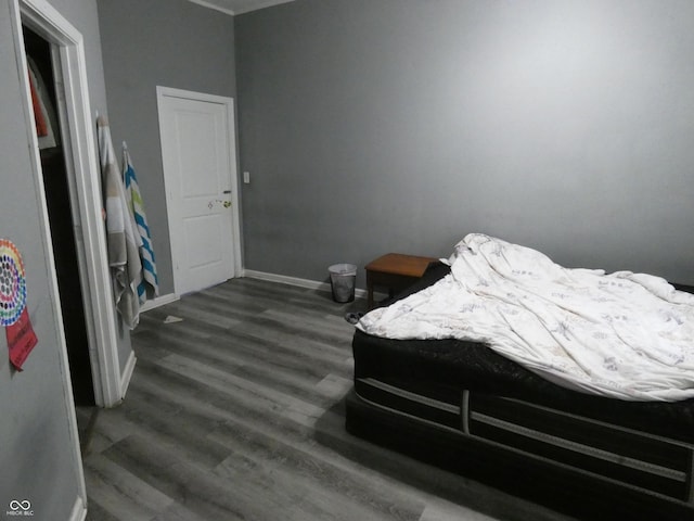 bedroom with baseboards and dark wood-style flooring