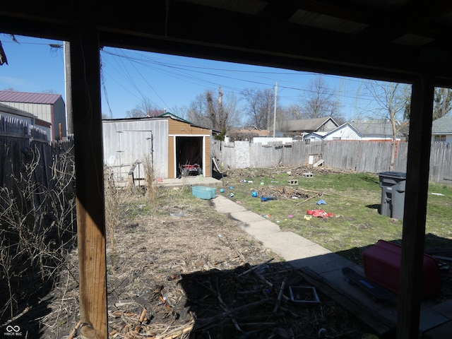 view of yard with a storage shed, an outbuilding, and a fenced backyard