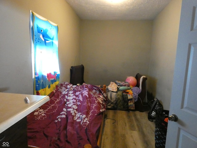 bedroom with wood finished floors and a textured ceiling