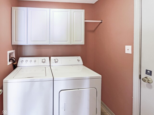 washroom featuring baseboards, cabinet space, and washing machine and clothes dryer