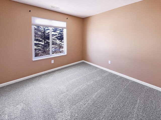 carpeted empty room featuring visible vents and baseboards