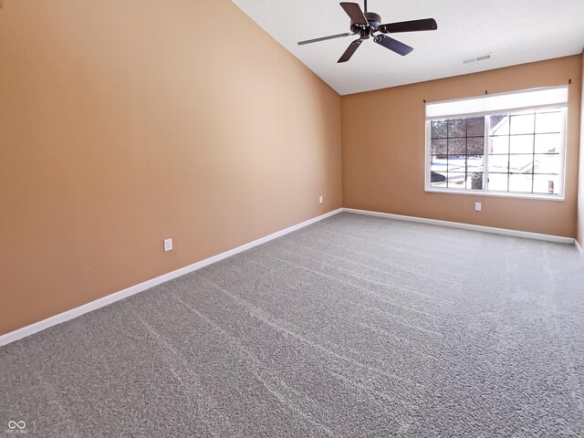 carpeted empty room featuring baseboards, lofted ceiling, visible vents, and ceiling fan