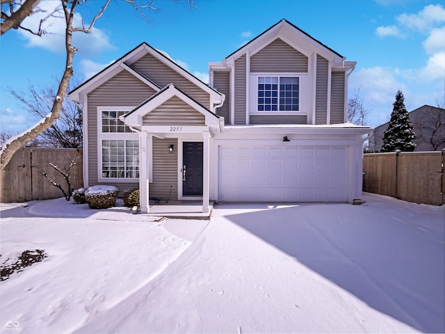 view of front of property with concrete driveway, a garage, and fence