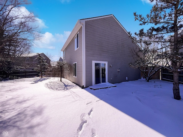 snow covered house with fence