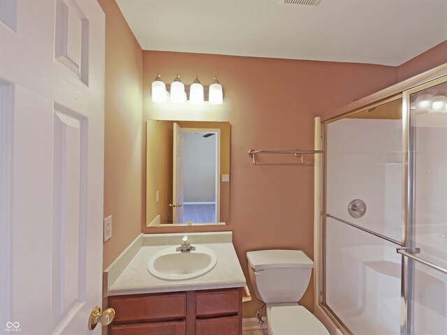 bathroom featuring visible vents, vanity, toilet, and a shower stall
