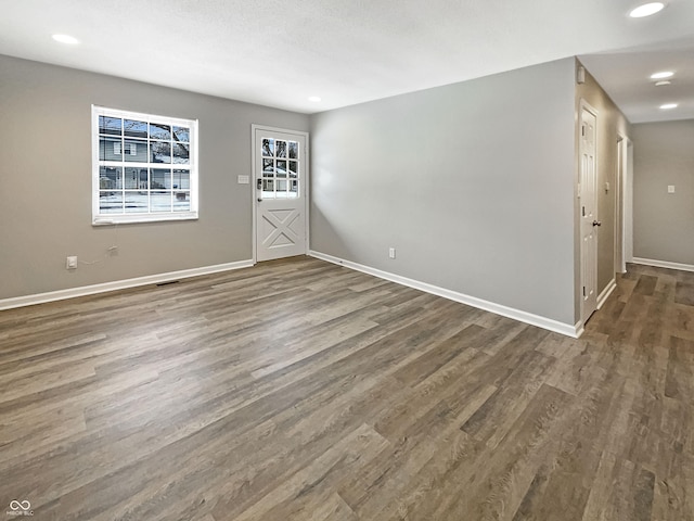 interior space with baseboards, wood finished floors, and recessed lighting