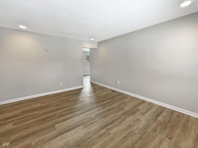 unfurnished room with baseboards, recessed lighting, and dark wood-style flooring