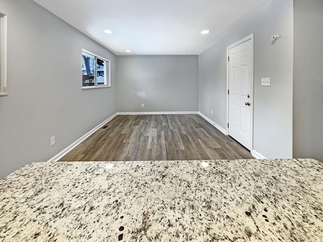unfurnished room with baseboards, wood finished floors, and recessed lighting