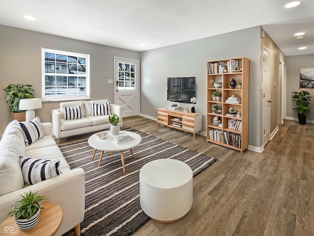 living area featuring baseboards, wood finished floors, and recessed lighting