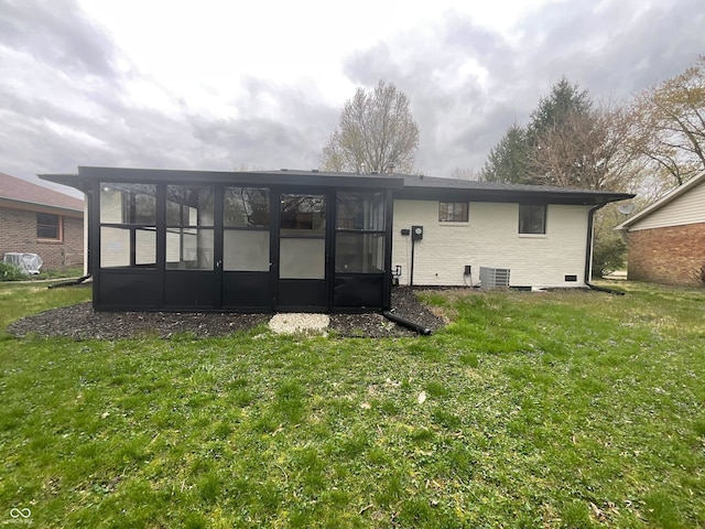 back of house featuring brick siding, a sunroom, a yard, and cooling unit