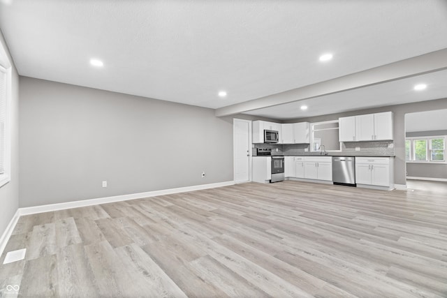 1641 Whistler Ter, Indianapolis, IN 46229 - kitchen with stainless steel appliances, open floor plan, light wood-type flooring, baseboards, and white cabinetry