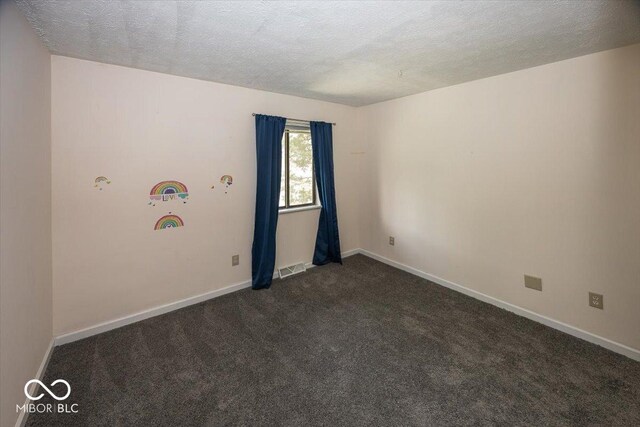 7965 Benjamin Dr, Lawrence, IN 46226 - spare room featuring a textured ceiling and dark colored carpet