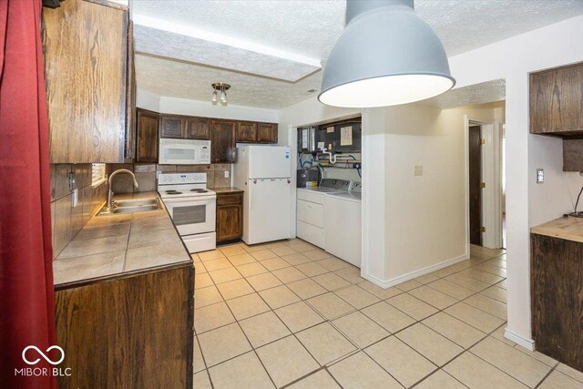 7965 Benjamin Dr, Lawrence, IN 46226 - kitchen with white appliances, independent washer and dryer, a textured ceiling, light tile patterned floors, and decorative backsplash