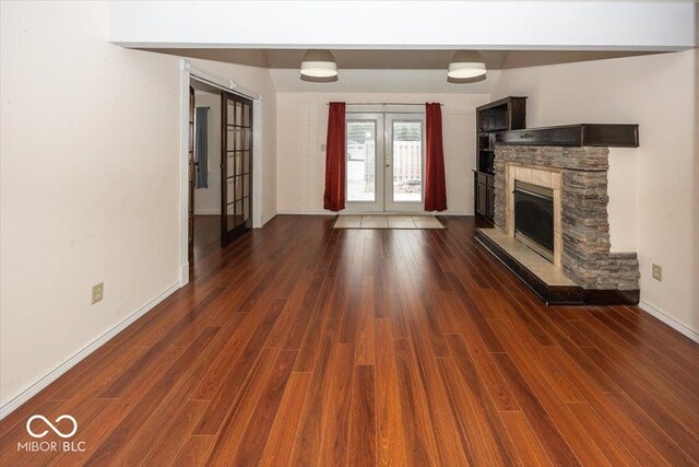 7965 Benjamin Dr, Lawrence, IN 46226 - unfurnished living room featuring french doors, a fireplace, and dark wood finished floors