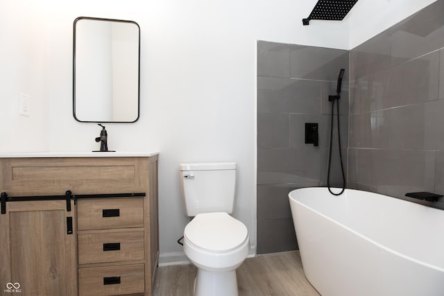 249 N Hamilton Ave, Indianapolis, IN 46201 - bathroom with vanity, toilet, a freestanding tub, wood finished floors, and tiled shower