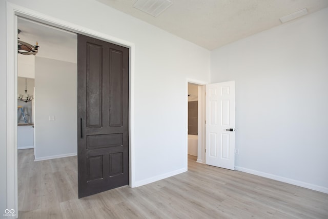 249 N Hamilton Ave, Indianapolis, IN 46201 - unfurnished room with light wood-style floors, baseboards, a chandelier, and visible vents