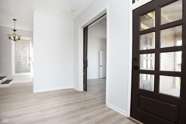 249 N Hamilton Ave, Indianapolis, IN 46201 - foyer with baseboards, light wood finished floors, and a notable chandelier