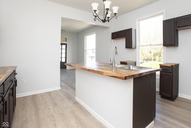 249 N Hamilton Ave, Indianapolis, IN 46201 - kitchen with a sink, an inviting chandelier, light wood-style flooring, and butcher block counters