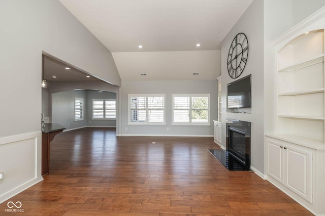 3792 Waterfront Way, Plainfield, IN 46168 - unfurnished living room featuring a fireplace with flush hearth, dark wood-type flooring, a healthy amount of sunlight, and built in shelves