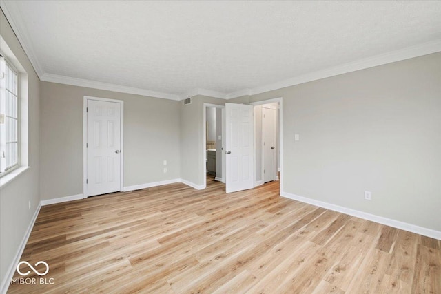 unfurnished bedroom with crown molding, light wood-style flooring, and baseboards
