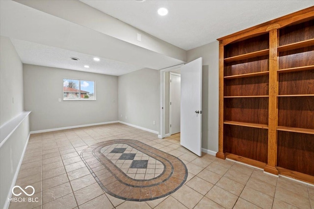 interior space featuring light tile patterned floors, recessed lighting, a textured ceiling, and baseboards