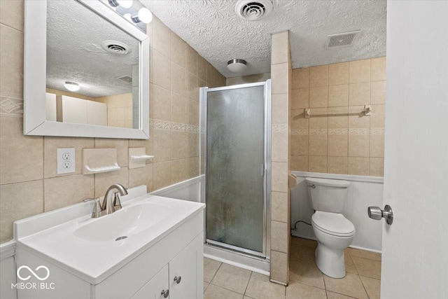 full bath with tile patterned floors, visible vents, tile walls, and a shower stall
