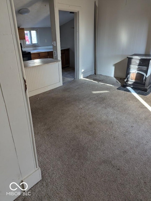 9278 S Geneva Rd, Flat Rock, IN 47234 - unfurnished living room featuring a wood stove and carpet floors