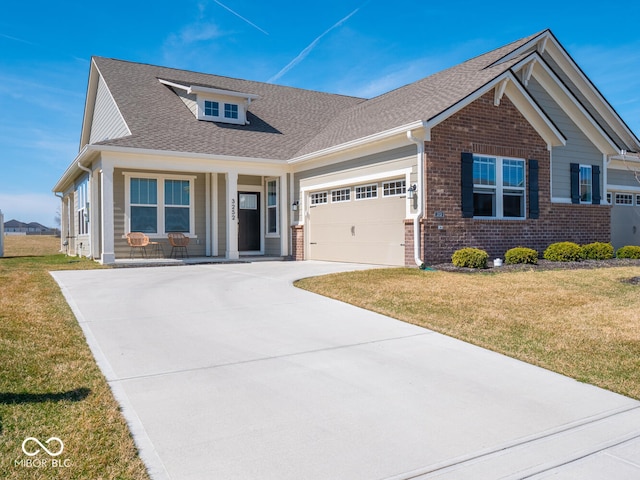 craftsman-style home featuring brick siding, concrete driveway, a front yard, covered porch, and a garage