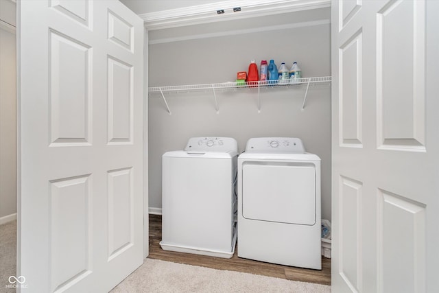 washroom featuring independent washer and dryer, wood finished floors, and laundry area
