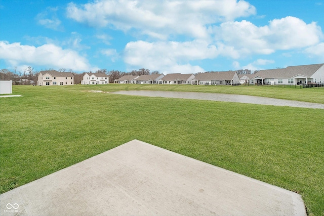 view of yard featuring a residential view and a water view