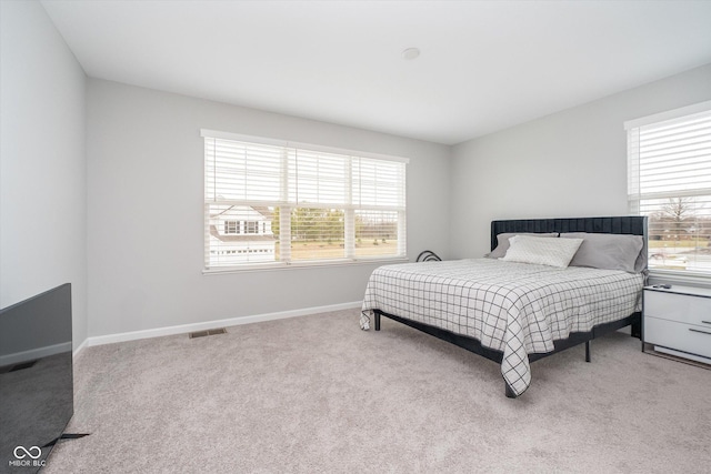 carpeted bedroom with baseboards and visible vents