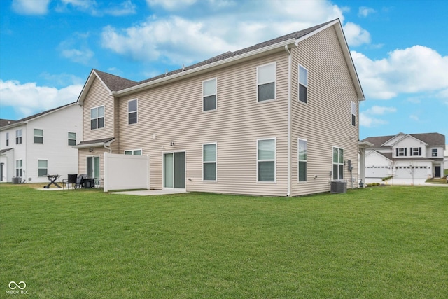 rear view of house featuring a lawn, central air condition unit, and a patio area