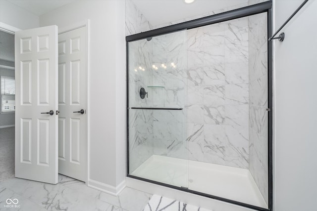 bathroom with marble finish floor, baseboards, and a marble finish shower