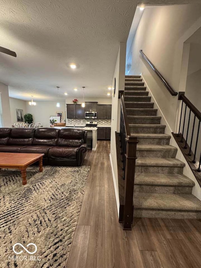 stairs featuring a textured ceiling, recessed lighting, and hardwood / wood-style floors