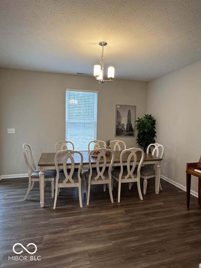 dining space with a notable chandelier, dark wood-style floors, baseboards, and a textured ceiling