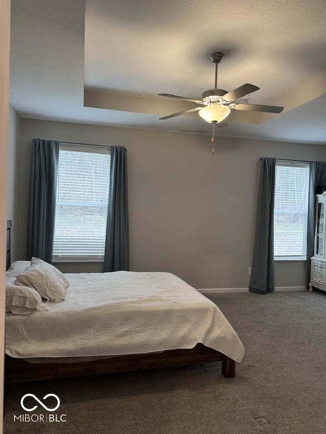 bedroom with baseboards, ceiling fan, carpet, and a textured ceiling