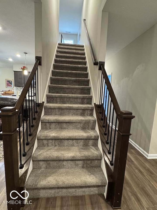 stairway with baseboards and wood finished floors