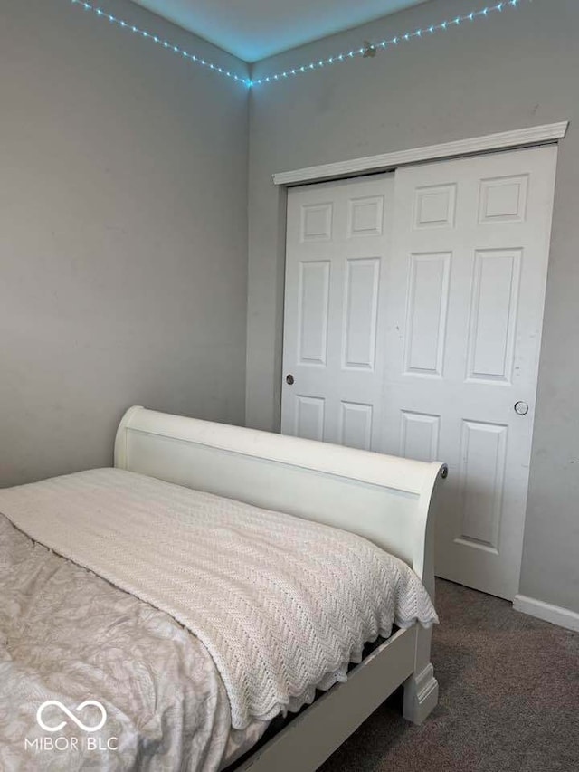 bedroom featuring carpet flooring, baseboards, and a closet
