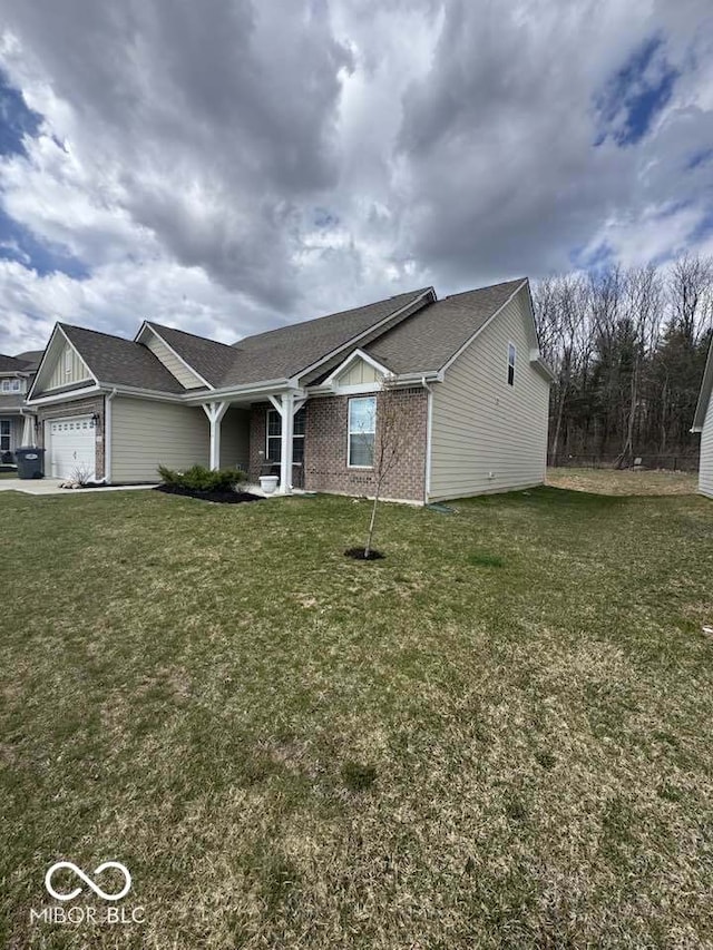 ranch-style house with a front yard, a garage, brick siding, and roof with shingles