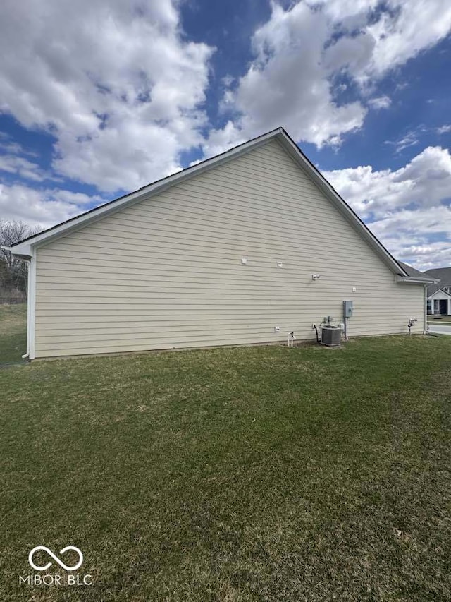 view of property exterior featuring central air condition unit and a yard