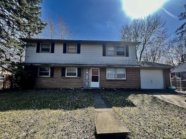 traditional-style house with brick siding, an attached garage, driveway, and a front lawn