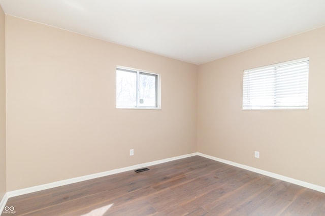 1701 Nelson Ave, Indianapolis, IN 46203 - spare room with visible vents, baseboards, and dark wood-type flooring