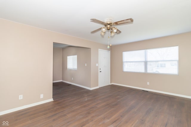 1701 Nelson Ave, Indianapolis, IN 46203 - spare room featuring dark wood-style floors, a healthy amount of sunlight, baseboards, and a ceiling fan