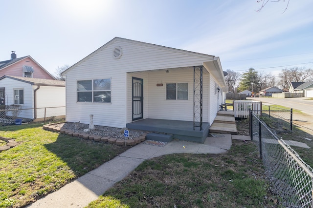 1701 Nelson Ave, Indianapolis, IN 46203 - bungalow featuring a porch, a fenced backyard, and a front lawn