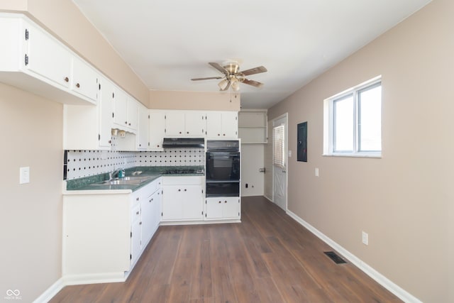 1701 Nelson Ave, Indianapolis, IN 46203 - kitchen featuring a ceiling fan, under cabinet range hood, black oven, backsplash, and dark wood-style floors